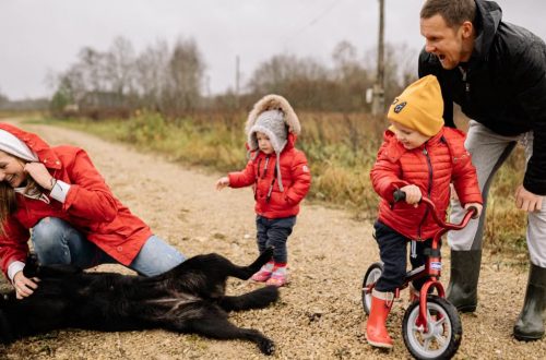 Happy family enjoying quality time outdoors with kids and dog in countryside.