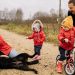 Happy family enjoying quality time outdoors with kids and dog in countryside.